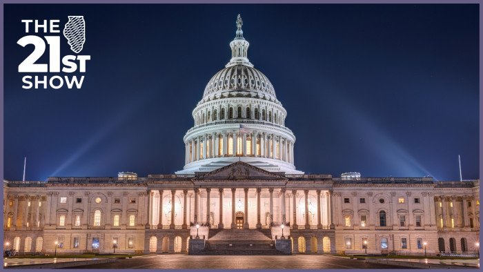 the ornate pillars and dome of the U.S. Capitol Building glow white and amber as they are illuminated against an indigo night sky