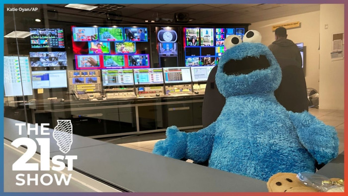 Cookie Monster stares into the middle distance from a control room at a PBS station in 2025, the year the federal government ended support for public broadcasting.