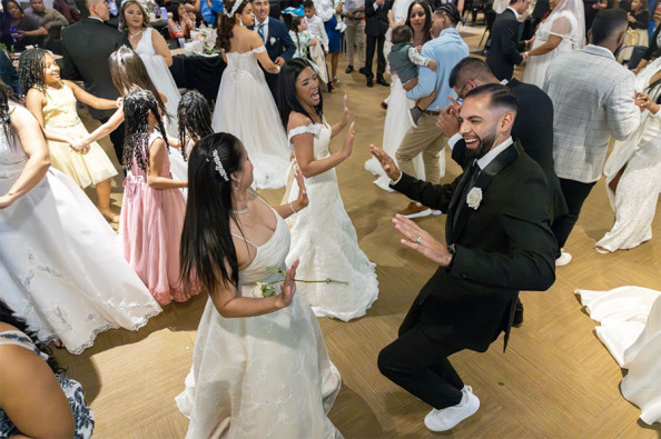 David Vargas and his wife, Daryenis, dance hours after they got married with 14 other migrant couples Friday night.