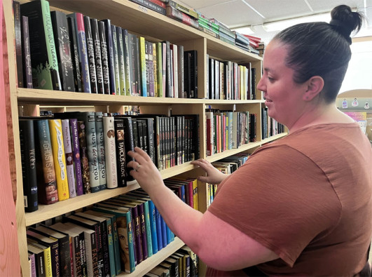 Peoria teacher Meredith Buneta looks through her favorite section, Young Adult, at the Book Rack.