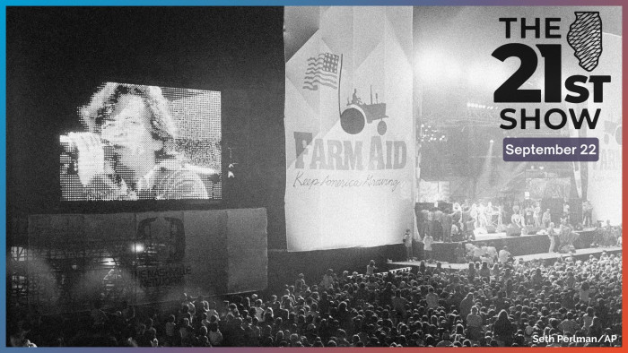 John Cougar Mellencamp performs both on stage and on one of two large screen television screens set up at the University of Illinois Memorial Stadium in Champaign, Ill. on Sept. 22, 1985 during the Farm Aid concert. 