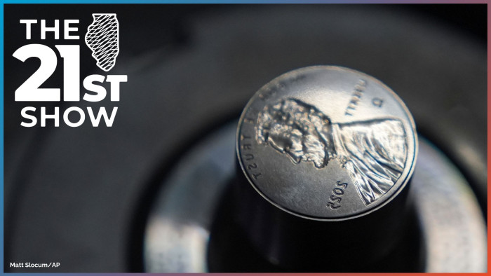 A dark gray cylinder of metal ends with the reverse image of the penny — the profile of Abraham Lincoln, plus LIBERTY, IN GOD WE TRUST, 2025, and the Greek letter omega.