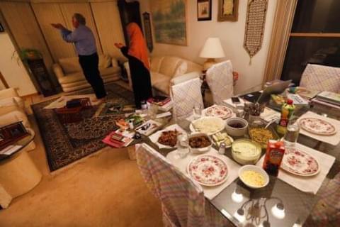 In this photo from April 28, 2020, Asghar Ali Khan and his wife, Shaheen, participate in the evening prayer as the Iftar, the evening meal with which Muslims end their daily Ramadan fast at sunset, waits on the dining room table at their Wheeling home.