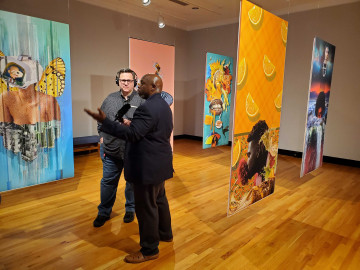 Host of The 21st show, Brian Mackey, interviews an artist inside Krannert Art Museum.