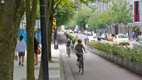 Cyclists ride in a separated bike lane in Vancouver, Canada. The idea behind a 15-minute city is that residents are able to reach all of their daily needs and amenities by no more than a 15-minute walk or bike ride.