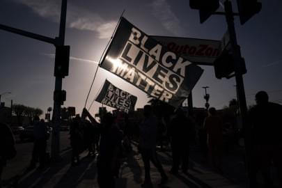 People hold Black Lives Matter flags at the intersection of Florence and Normandie Avenues, Tuesday, April 20, 2021, in Los Angeles, after a guilty verdict was announced at the trial of former Minneapolis police Officer Derek Chauvin for the 2020 death of George Floyd.