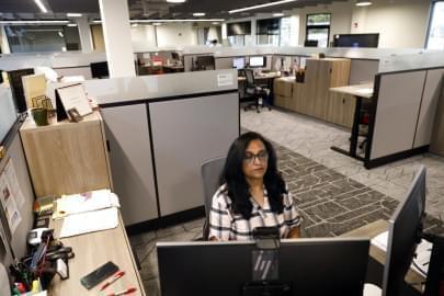 Shobha Surya, associate manager for projects and sales operations of Ajinomoto, a global food and pharmaceutical company, works in a shared office space in Itasca, Ill., Monday, June 7, 2021. Surya said she feels energized by the light pouring in from skylights at the new headquarters, adding that she missed her colleagues and is thrilled to be back in-person. 