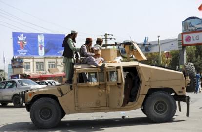 Taliban fighters stand guard in front of the Hamid Karzai International Airport, in Kabul, Afghanistan, Monday, Aug. 16, 2021. Thousands of people packed into the Afghan capital's airport on Monday, rushing the tarmac and pushing onto planes in desperate attempts to flee the country after the Taliban overthrew the Western-backed government.