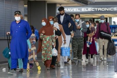 In this Tuesday, Aug. 31, 2021, file photo, families evacuated from Kabul, Afghanistan, walk through the terminal to board a bus after they arrived at Washington Dulles International Airport, in Chantilly, Va. U.S. religious groups of many faiths are gearing up to assist the thousands of incoming refugees. 