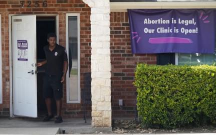 In this Wednesday, Sept. 1, 2021 file photo, a security guard opens the door to the Whole Women's Health Clinic in Fort Worth, Texas. A Texas law banning most abortions in the state took effect at midnight.