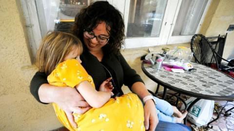Sarah Clemente snuggles with daughter Penelope Clemente, 6, at their home in Charleston, W.Va., on Saturday, Oct. 30, 2021. Clemente supported a paid family medical leave proposal that was removed from President Joe Biden's social spending plan because of opposition from West Virginia Sen. Joe Manchin.