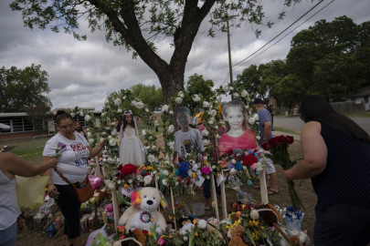 Dorina Davila, left, from San Antonio, places flowers at a memorial outside Robb Elementary School in Uvalde, Texas, Monday, May 30, 2022. In a town as small as Uvalde, even those who didn't lose their own child lost someone. Some say now that closeness is both their blessing and their curse: they can lean on each other to grieve. But every single one of them is grieving.