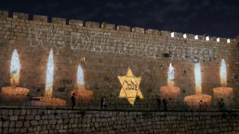 An image of a yellow Star of David that reads "Jude," or Jew in German, resembling the one Jews were forced to wear in Nazi Germany, is projected on the walls of Jerusalem's Old City on the eve of annual Holocaust Remembrance Day, Monday, April 17, 2023. Israel holds the day of remembrance each year to remember the six million Jewish victims of the Nazi genocide during World War II.