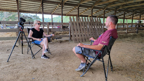 woman interviews man in barn