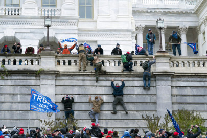 Violent insurrectionists loyal to President Donald Trump scale the west wall of the U.S. Capitol in Washington, Jan. 6, 2021.