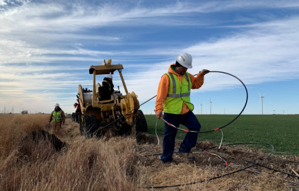 A contractor installs fiber-optic cable next to a field in Ford County for Ideatek, a local broadband company based in the town of Buhler. Ideatek has used fiber lines like this one to bring high-speed internet to several towns with populations of just a few hundred people in southwest Kansas.