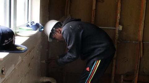 Kobe Smith, 17, helps gut an old house that belongs to the Housing Authority of Champaign County.