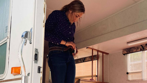 girl adjusts belt in trailer