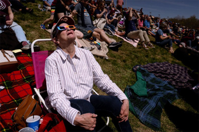 Kathy Ferris, 76, of University City, watches the partial eclipse on Monday at Saluki Stadium in Carbondale, Ill.