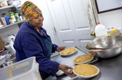 Pastry chef Carla Jones loads a trio of sweet potato pies onto a tray destined for the oven on Nov. 15 at Ol’ Henry’s Restaurant in Berkeley, Missouri. Sweet potato pie is a significant touchstone of African American culture, especially around Thanksgiving.
