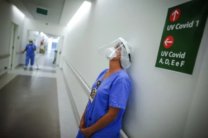 A health care worker lends against a wall in the corridor of an ICU unit for COVID-19 patients at a hospital in Brazil in March 2021.