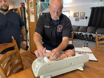 Project Swaddle paramedic Darren Forman sets five-week-old Wilder on a scale to monitor his growth.