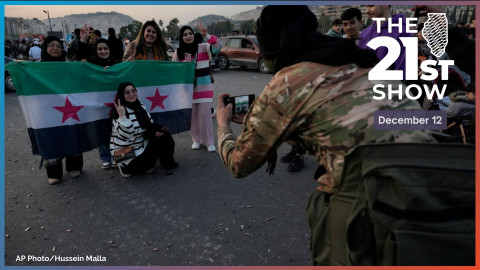 A Syrian opposition fighter takes pictures for citizens, who carry the revolutionary flag, as they are celebrating during the second day of the take over of the city by the insurgents in Damascus, Syria, Monday, Dec. 9, 2024.