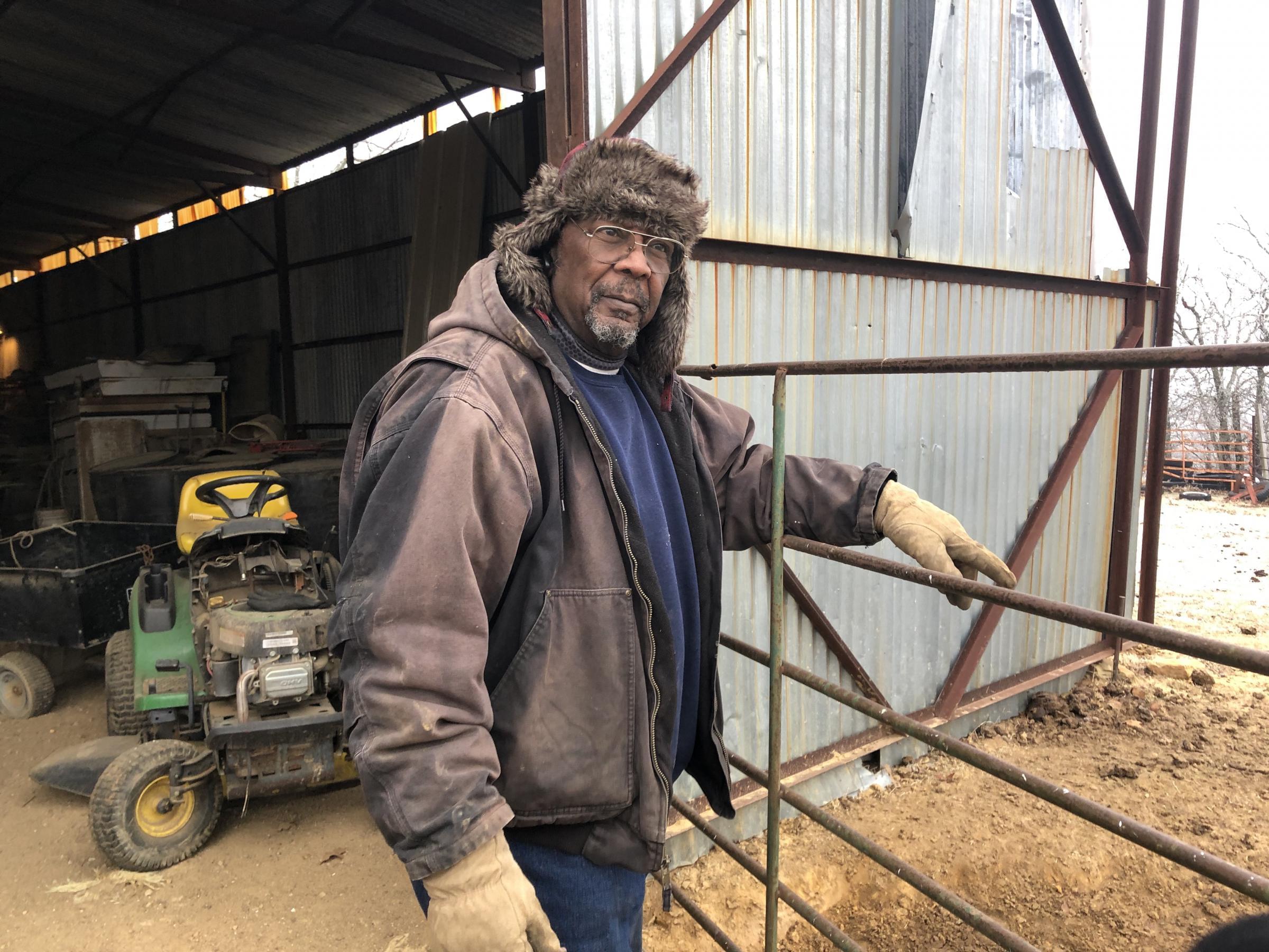 Alvin Lee watches his cows outside his barn near Wewoka, Oklahoma. He has about about 20 cows and 160 acres of land.