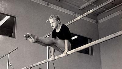 a young girl exercising on a balance beam