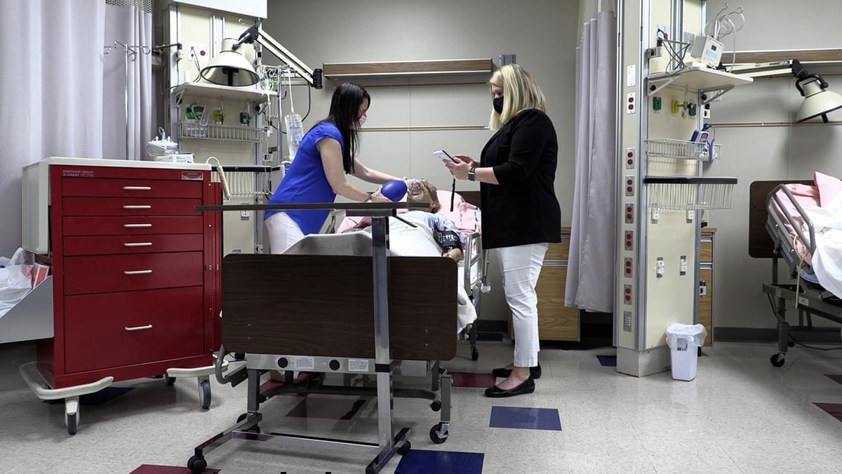 Nursing school instructors Erin McGuire and Kristin Yosanovich demonstrate how they use dummies to teach students.