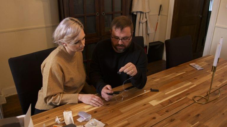 William Rentel checks his blood sugar while his wife Angela looks on.